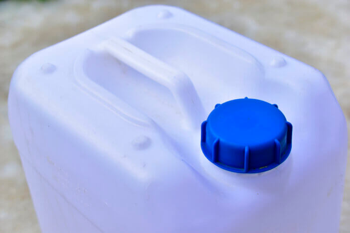 White plastic canister with blue lid in different positions